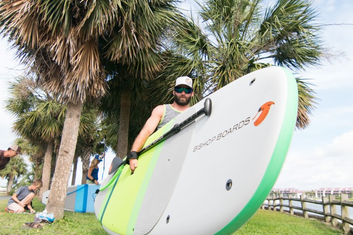 man holding a bishop paddle board