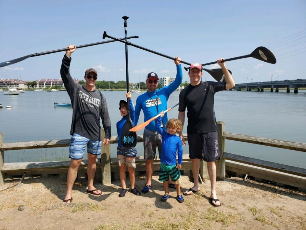 a group of people on a beach posing for the camera